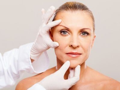 A cosmetóloga examina a pel facial do paciente